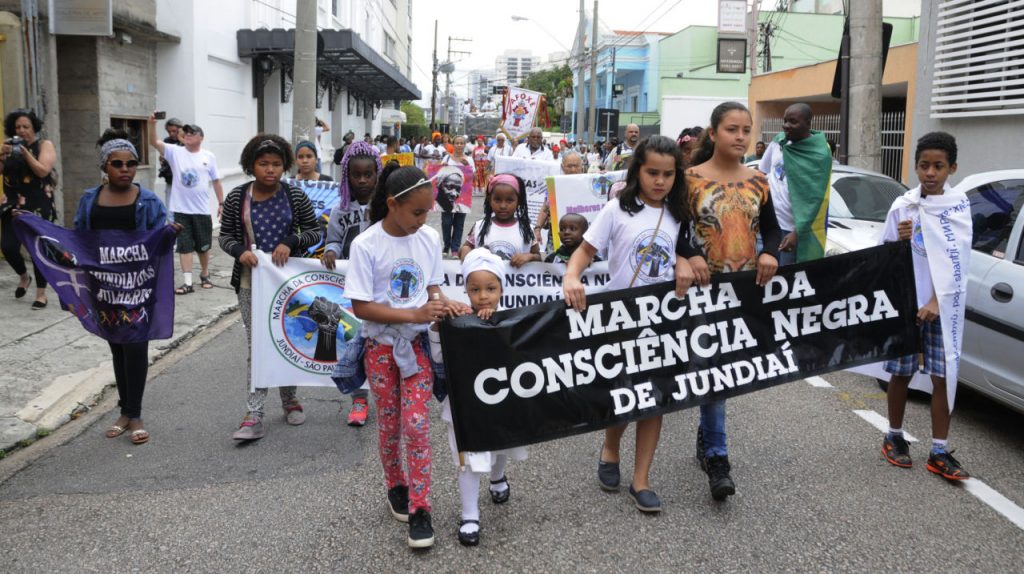 Crianças com faixas alusivas à conscientização negra marcham pela rua Barão de Jundiaí em edição anterior da Marcha da Consciência.