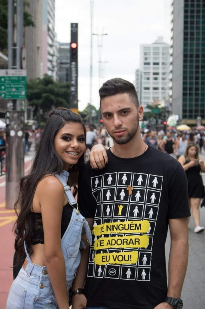 Foto de uma menina apoiada no ombro de um garoto, ambos na Avenida Paulista, parte do Rolê.