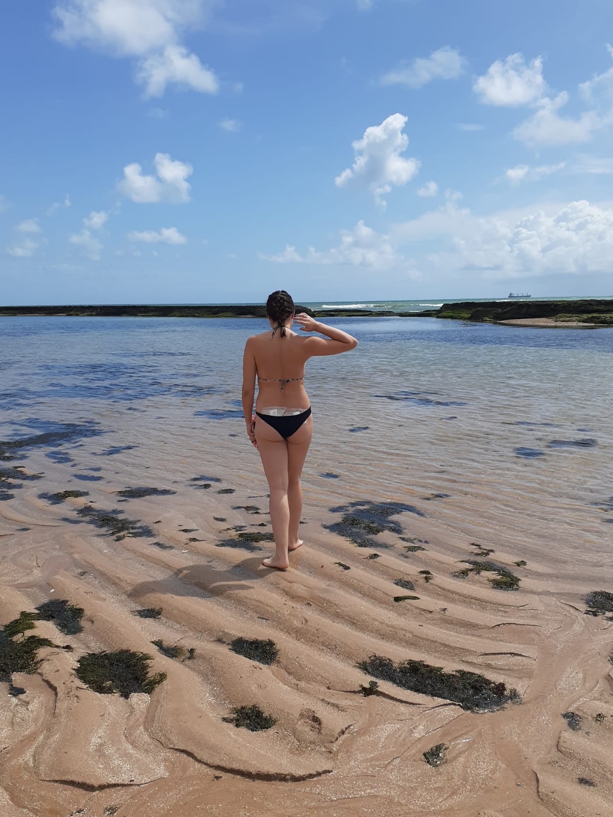 Mulher de costas na praia em Recife. Bauruense que viajou mais de 2 mil km para doar medula óssea relata sua experiência: "Faria tudo de novo"