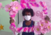 Na foto, uma mulher segundo um arco rosa, participando das ações do Outubro Rosa em Bauru