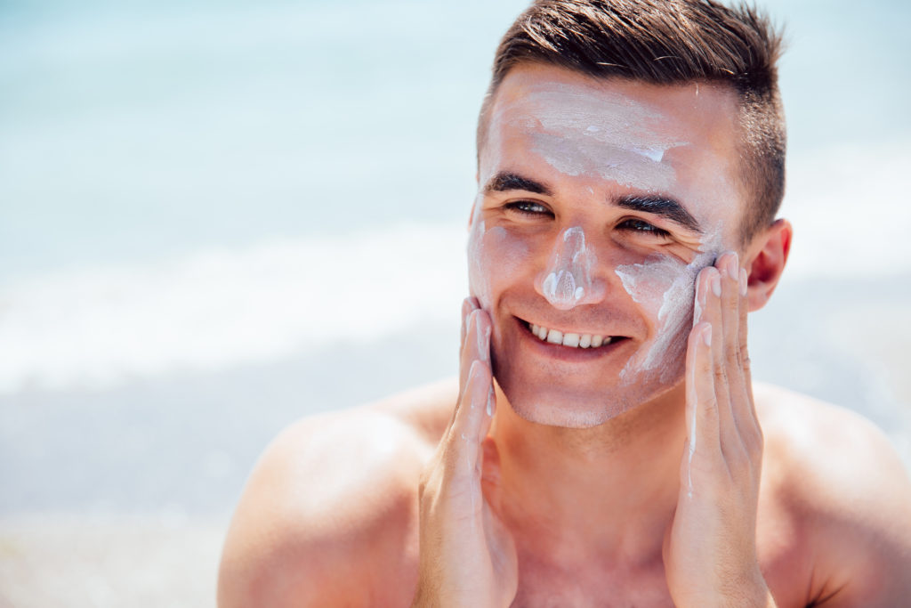 Na foto, homem passando protetor solar no rosto. Matéria: Dermatologista bauruense explica quais os principais cuidados com a pele e o cabelo no verão